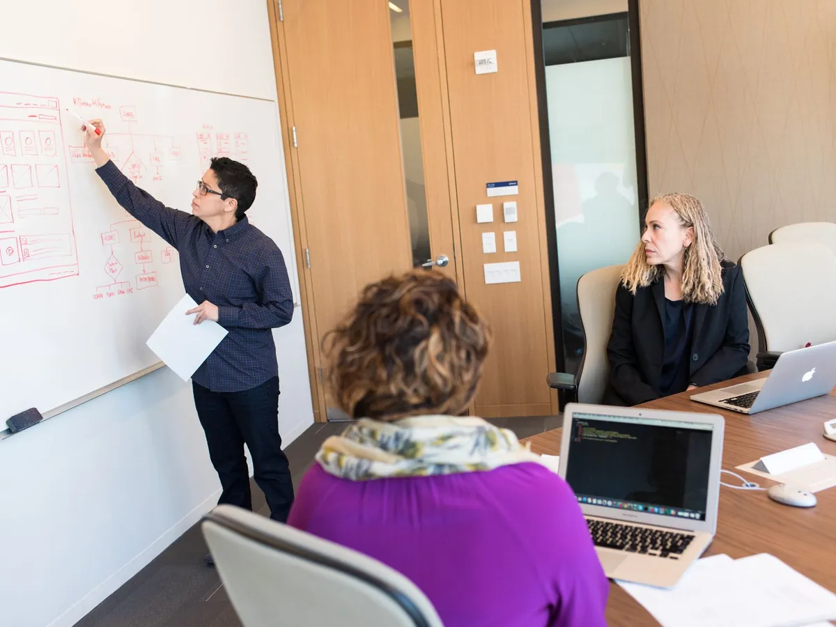 Groupe de professionnels en réunion collaborative, avec des outils technologiques