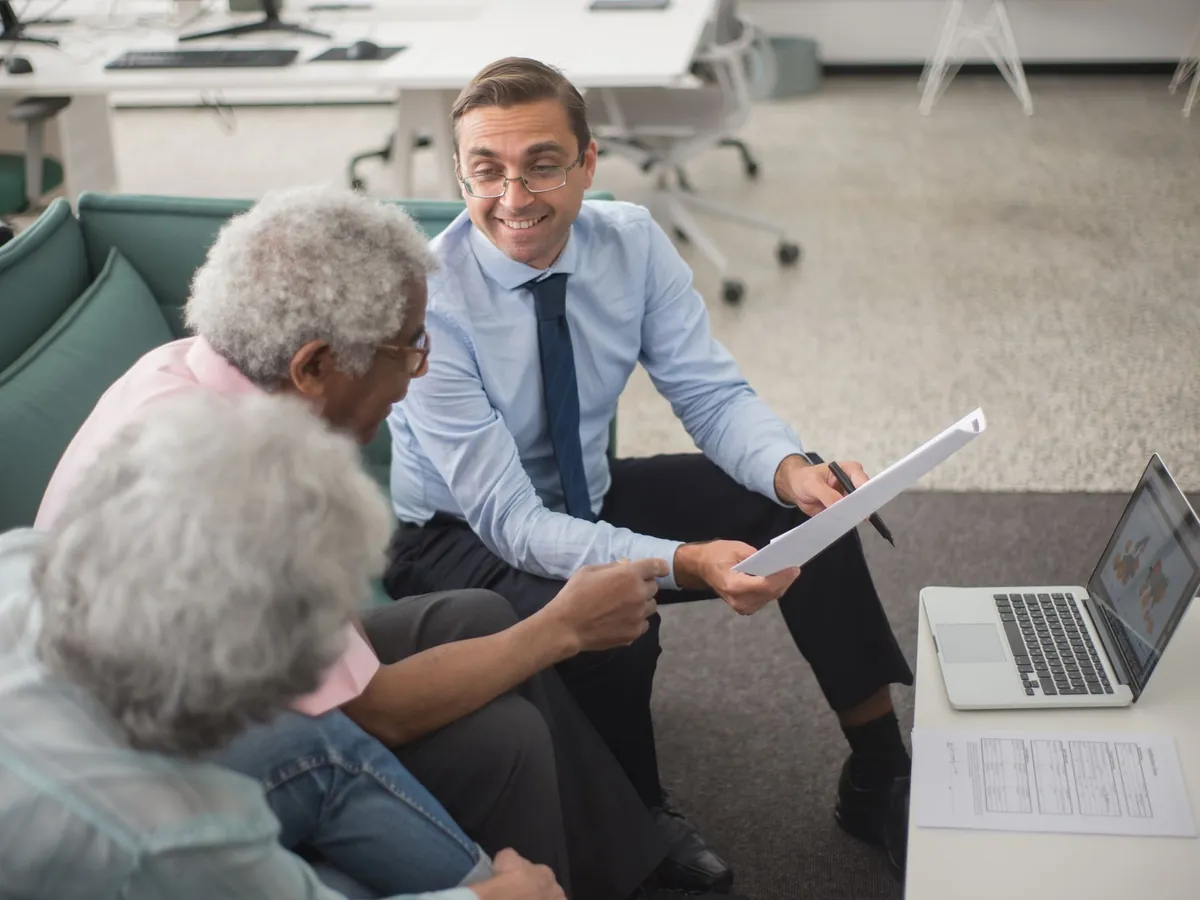 Consultant échangeant avec des clients sur des plans financiers, dans un bureau moderne