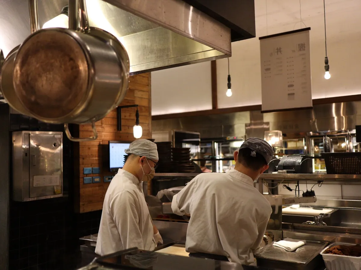 Deux chefs travaillant en cuisine professionnelle, en équipe