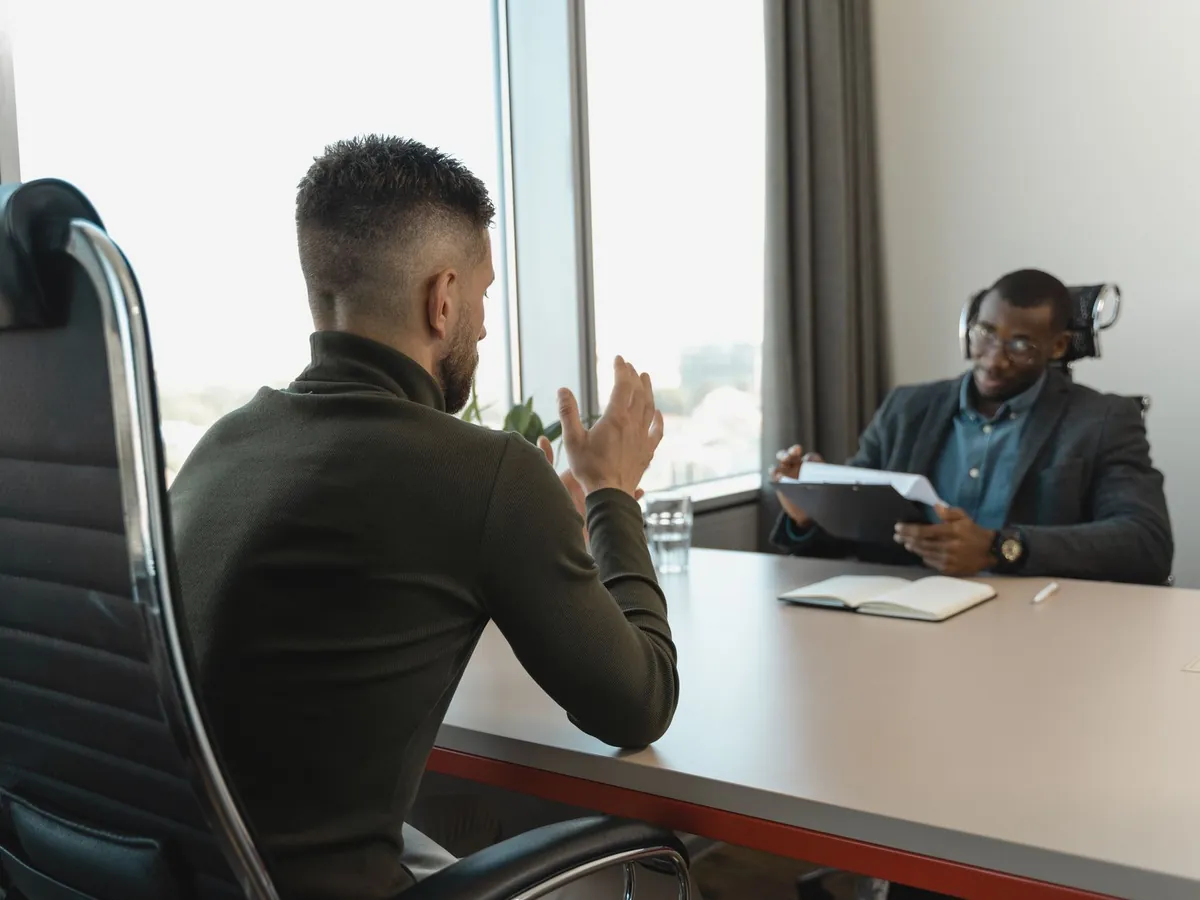 Deux hommes en entretien d'embauche dans un bureau moderne aux grandes baies vitrées