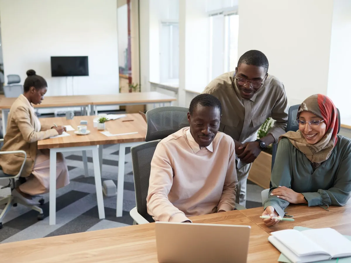 Groupe de collègues aux profils variés en pleine collaboration dans un bureau moderne