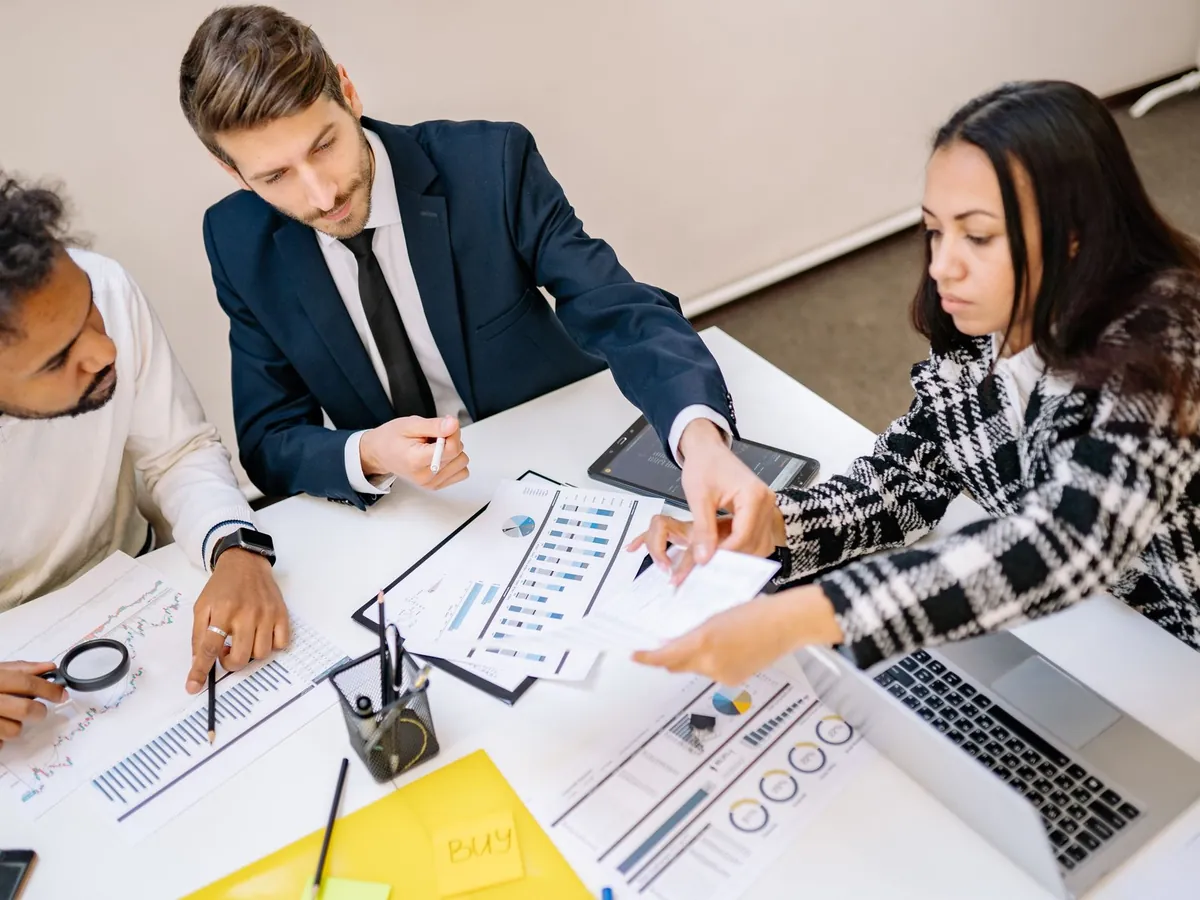 Professionnels d'entreprise en réunion de travail, graphiques et documents sur la table