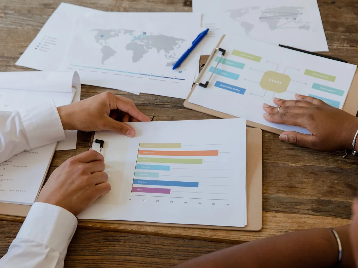 Vue de dessus de collègues discutant de graphiques et de diagrammes sur une table en bois
