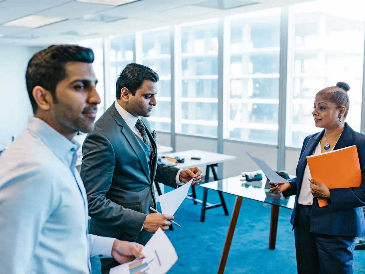 Professionnels discutant de documents dans un environnement de bureau moderne