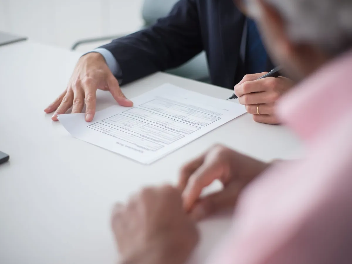 Deux professionnels en réunion d'affaires signant des documents pour un contrat de conseil