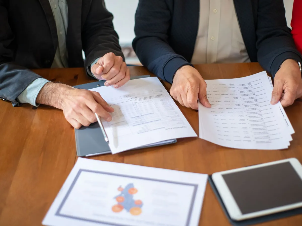 Deux professionnels d'entreprise examinant des documents pendant une réunion
