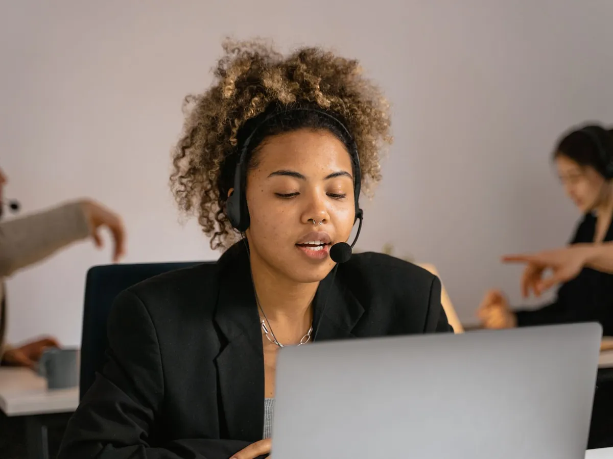 Conseiller du service client, casque sur la tête, travaillant sur un ordinateur portable au bureau