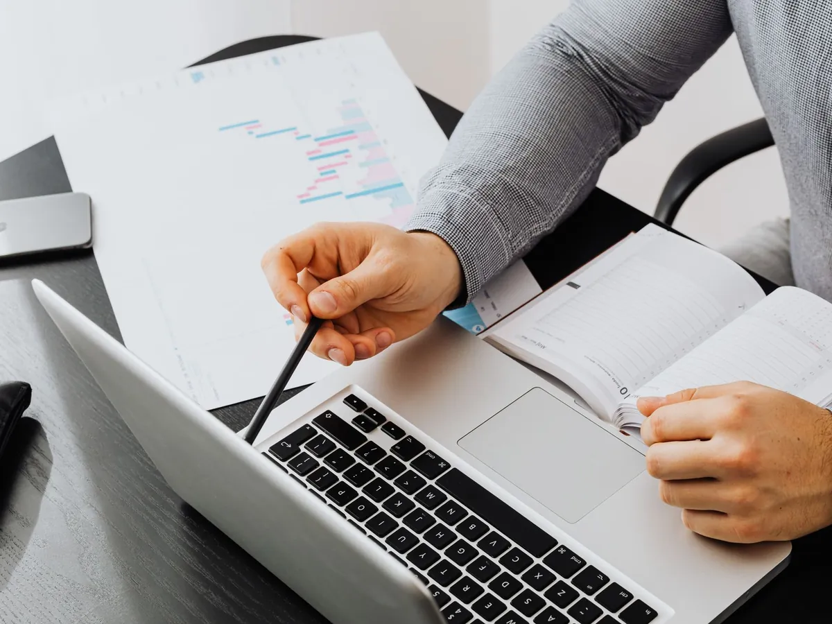 Professionnel consultant des documents et son ordinateur portable pour une analyse de données