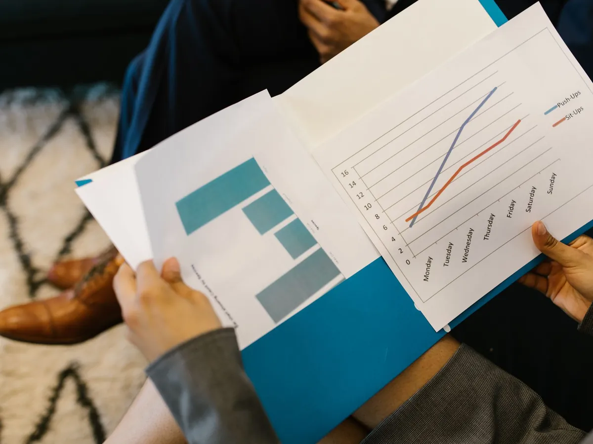 Gros plan sur des rapports d'activité accompagnés de graphiques, pendant une réunion d'entreprise