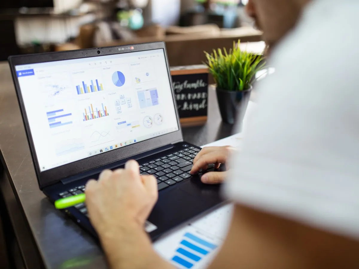 Analyse commerciale concentrée : graphiques et diagrammes sur un ordinateur portable, bureau moderne