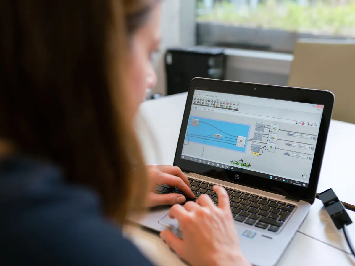 Ingénieure analysant un logiciel sur un ordinateur portable en intérieur