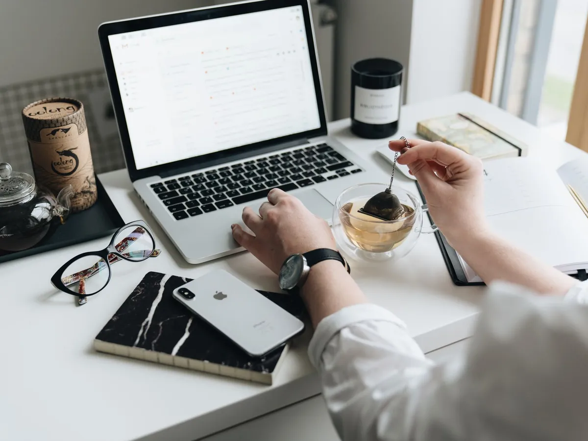 Coin bureau cosy à domicile avec ordinateur portable, thé et matériel de travail