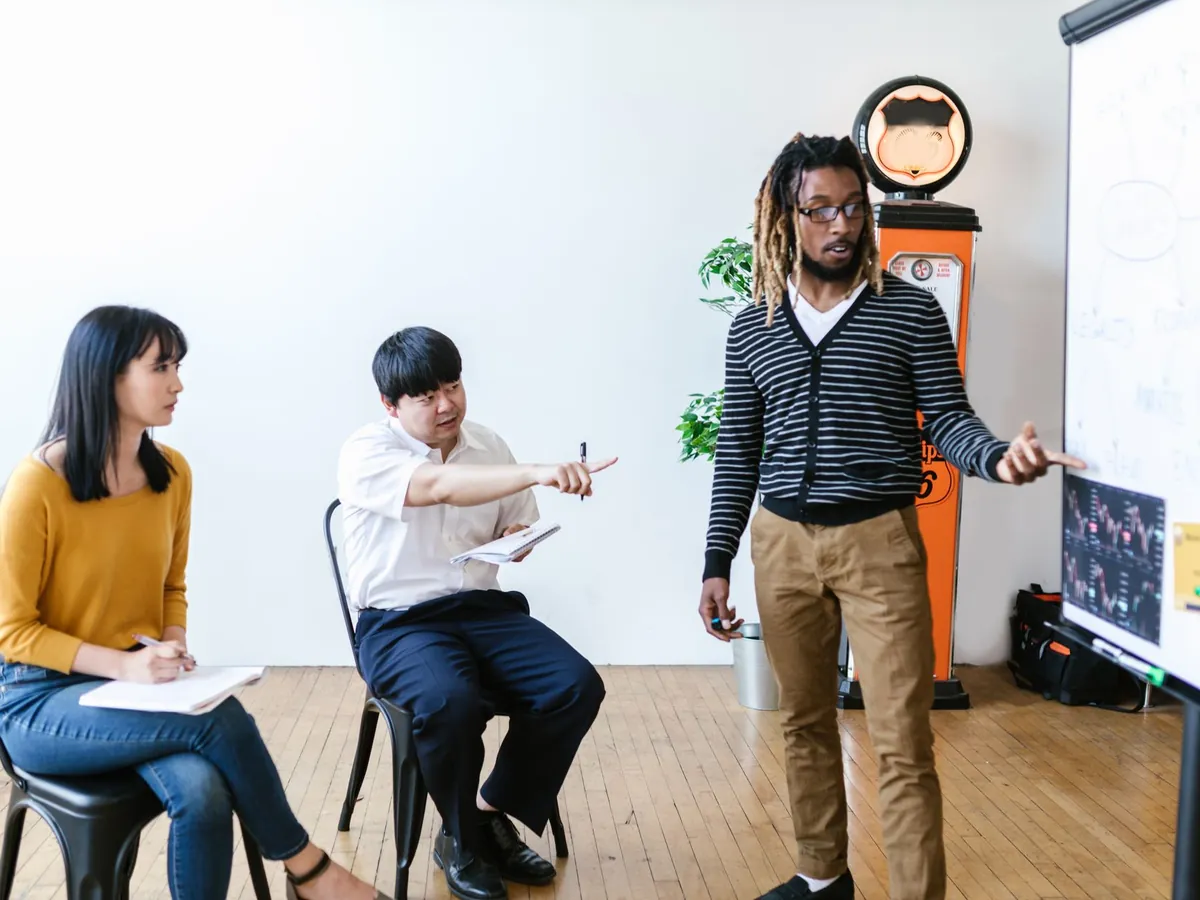 Groupe d'adultes aux profils variés en session de formation, suivant activement une présentation