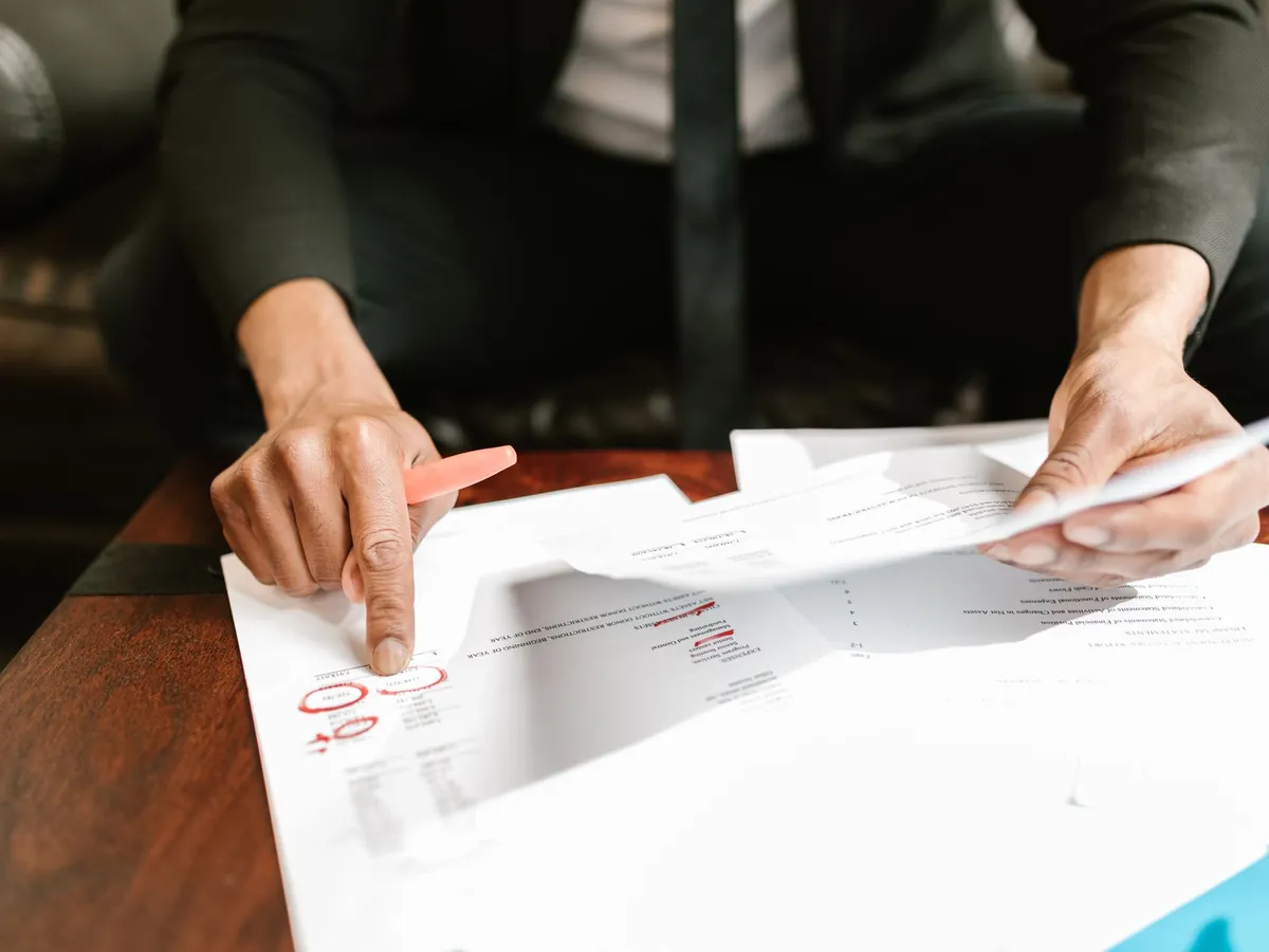 Homme d'affaires analysant des documents financiers et des chiffres clés sur son bureau