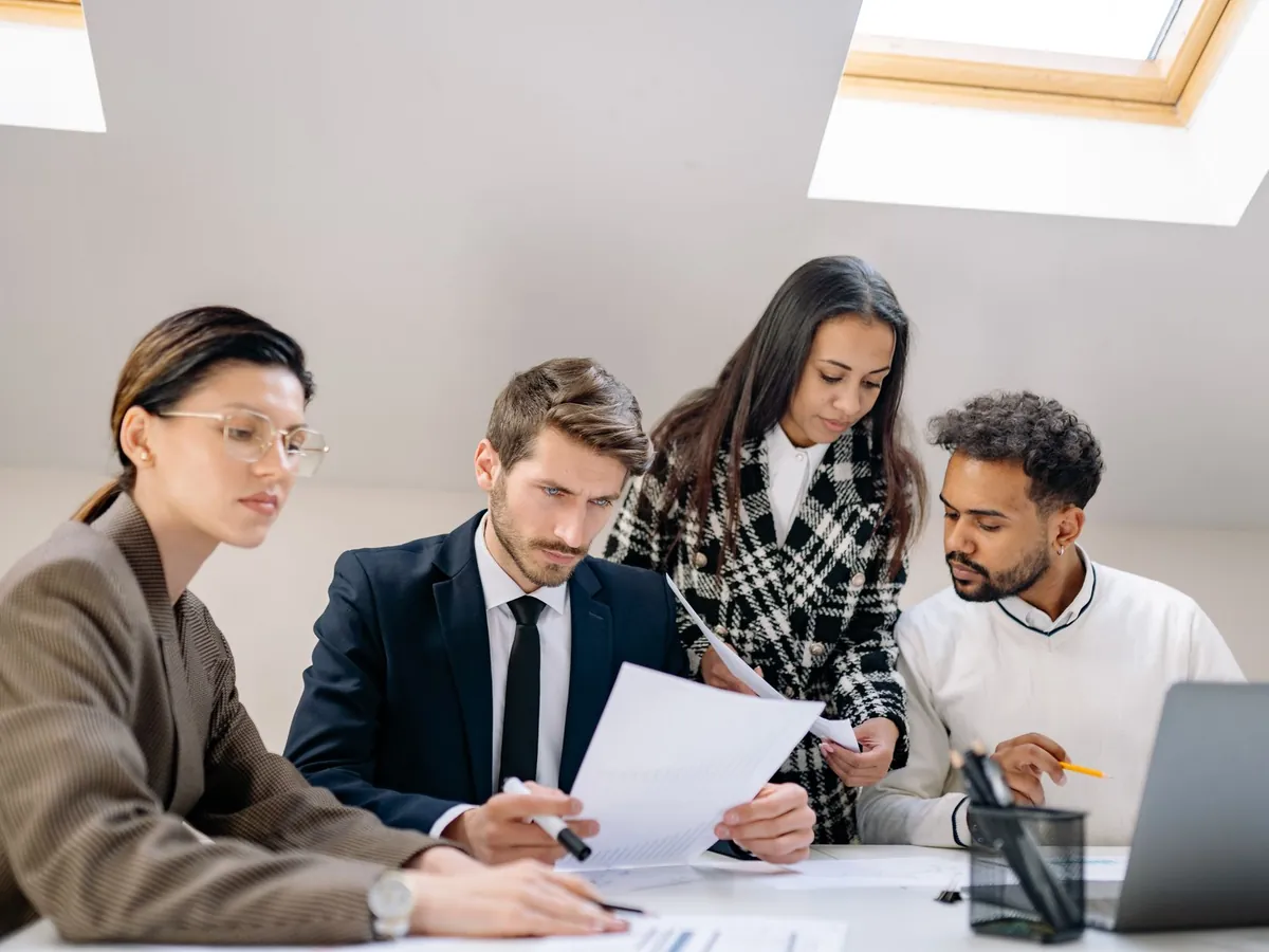Équipe diversifiée travaillant ensemble au bureau, échangeant sur des documents et des stratégies