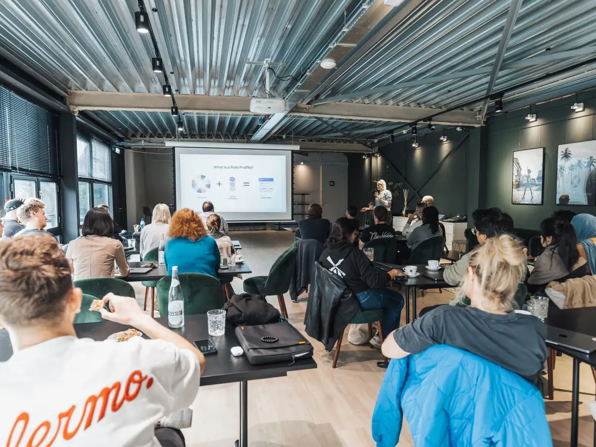 Groupe diversifié assistant à une présentation d'entreprise dans un espace au style industriel