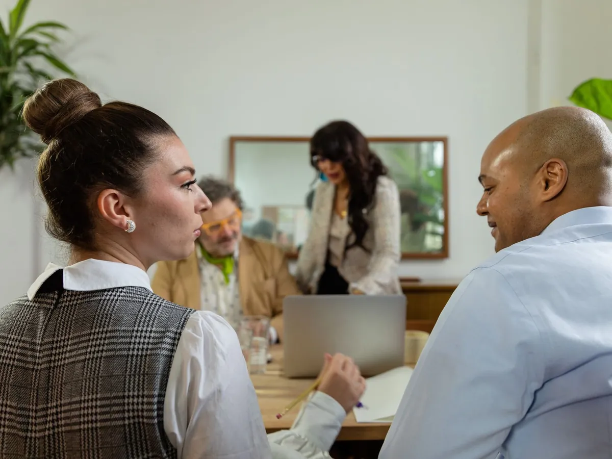 Équipe de bureau engagée dans une discussion autour d'un ordinateur portable, favorisant la collaboration