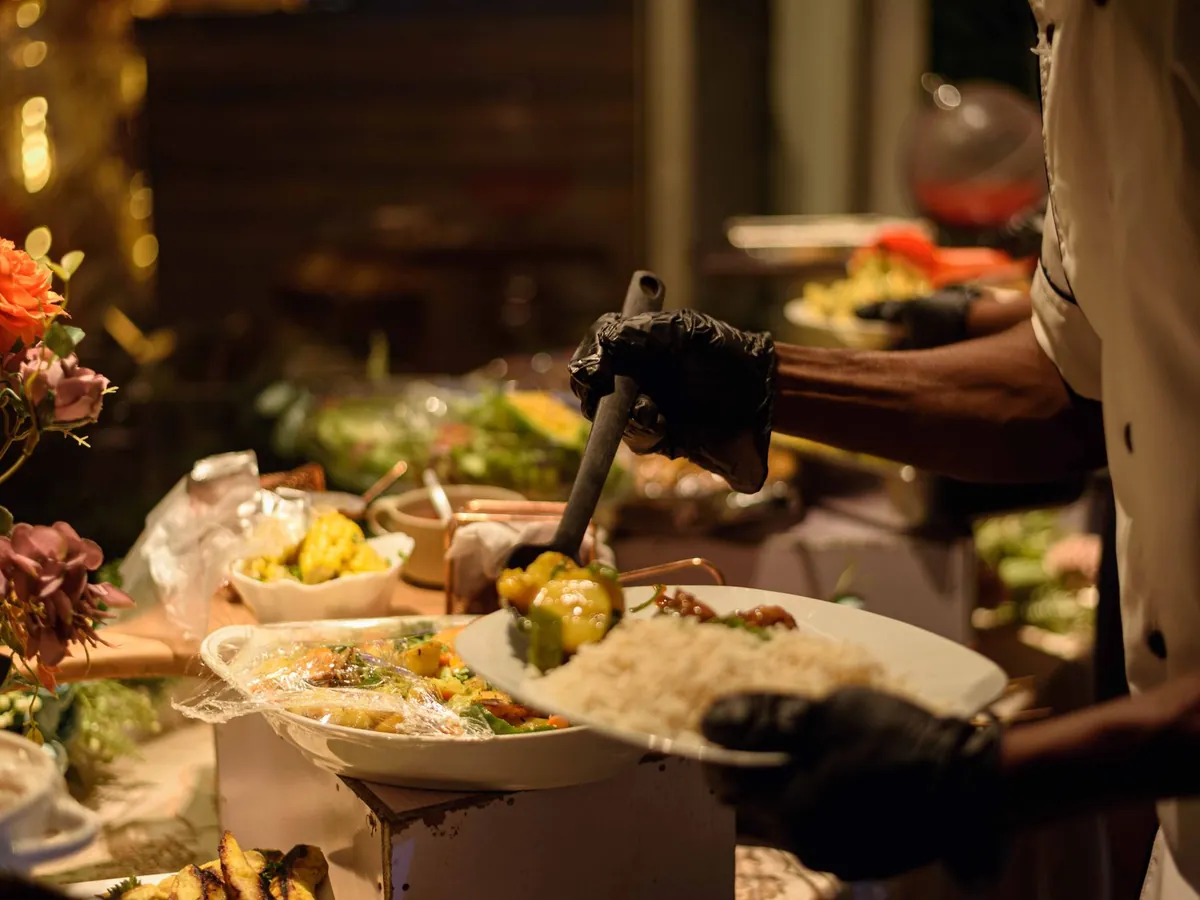 Chef servant des plats traditionnels nigérians sur un buffet élégant à Enugu