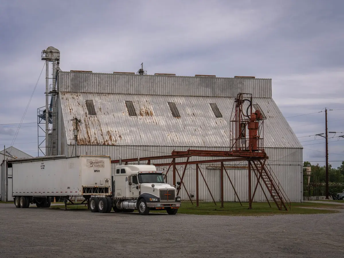 Entrepôt industriel rustique avec un semi-remorque garé, illustrant l'industrie rurale et la logistique
