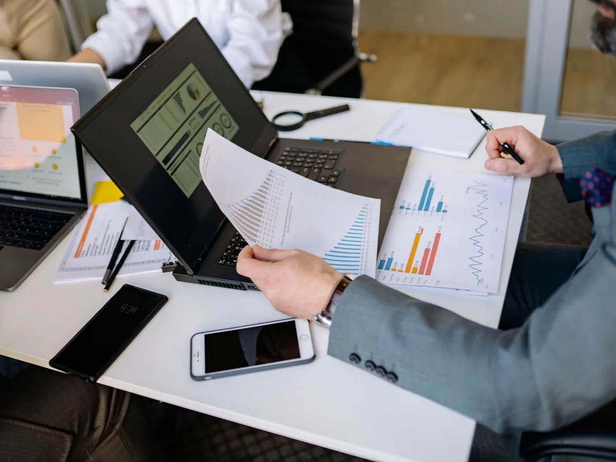 Professionnels analysant des graphiques sur leurs ordinateurs portables pendant une réunion d'affaires