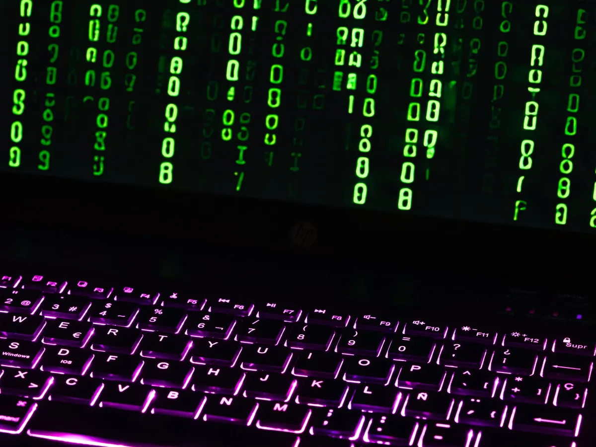 Clavier d'ordinateur portable éclairé, avec du code vert façon Matrix défilant à l'écran