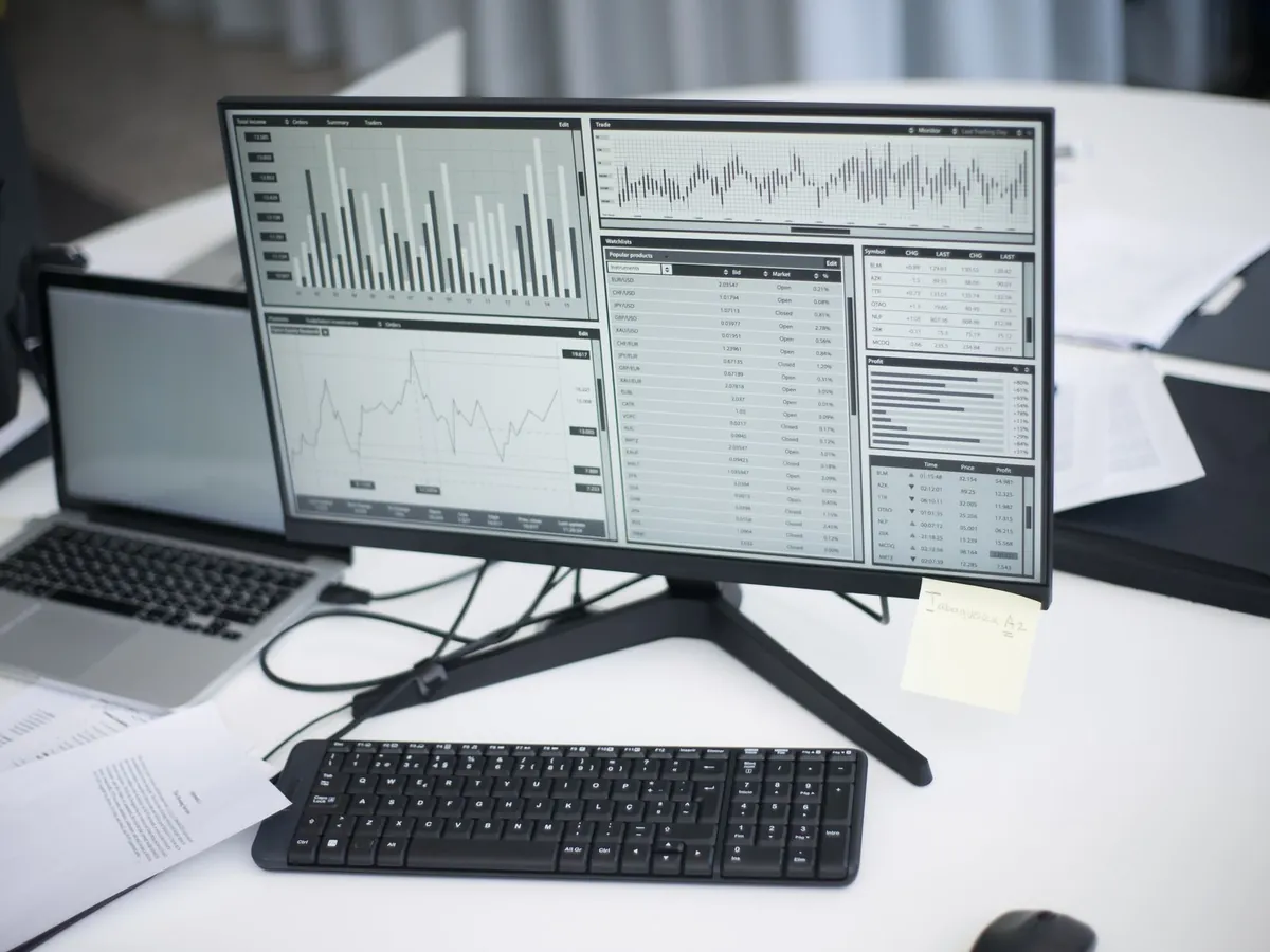 Espace de travail professionnel avec ordinateurs et graphiques d'analyse à l'écran