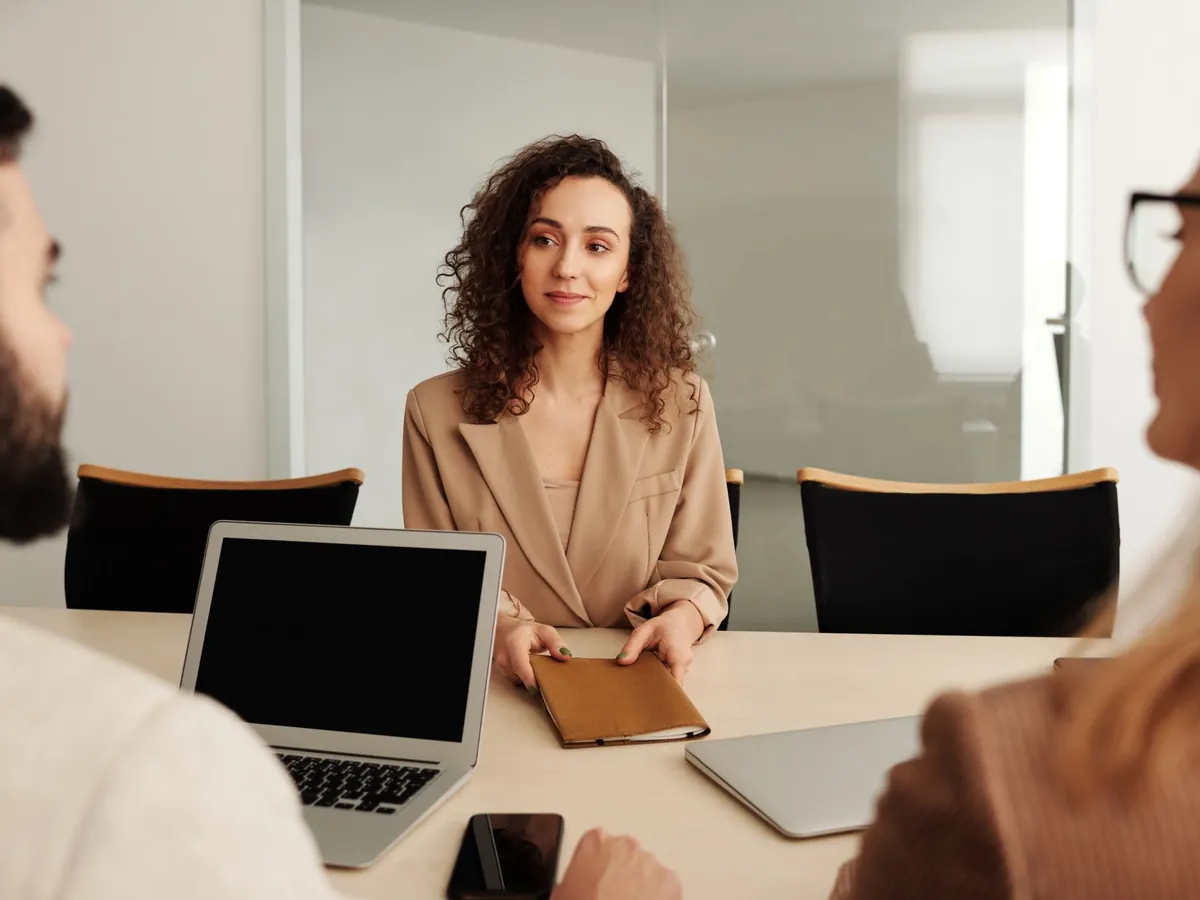 Femme en tailleur participant à un entretien d'embauche, dans un environnement de bureau moderne