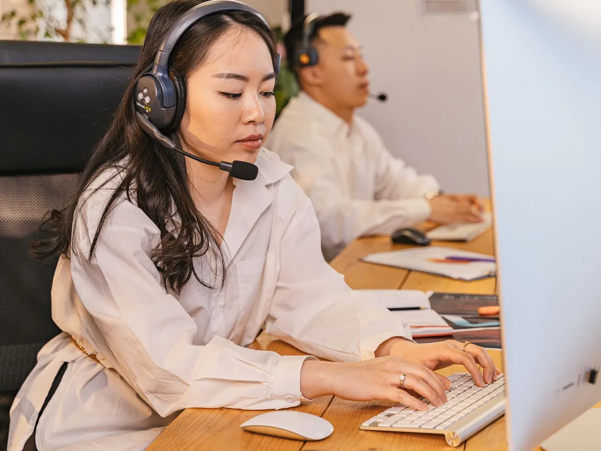 Professionnels de centre d'appels concentrés sur leurs tâches, casque sur la tête, dans un bureau moderne