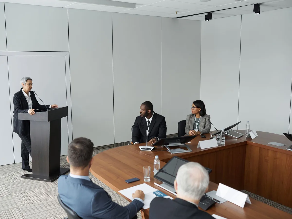 Groupe de professionnels en réunion avec un intervenant au pupitre