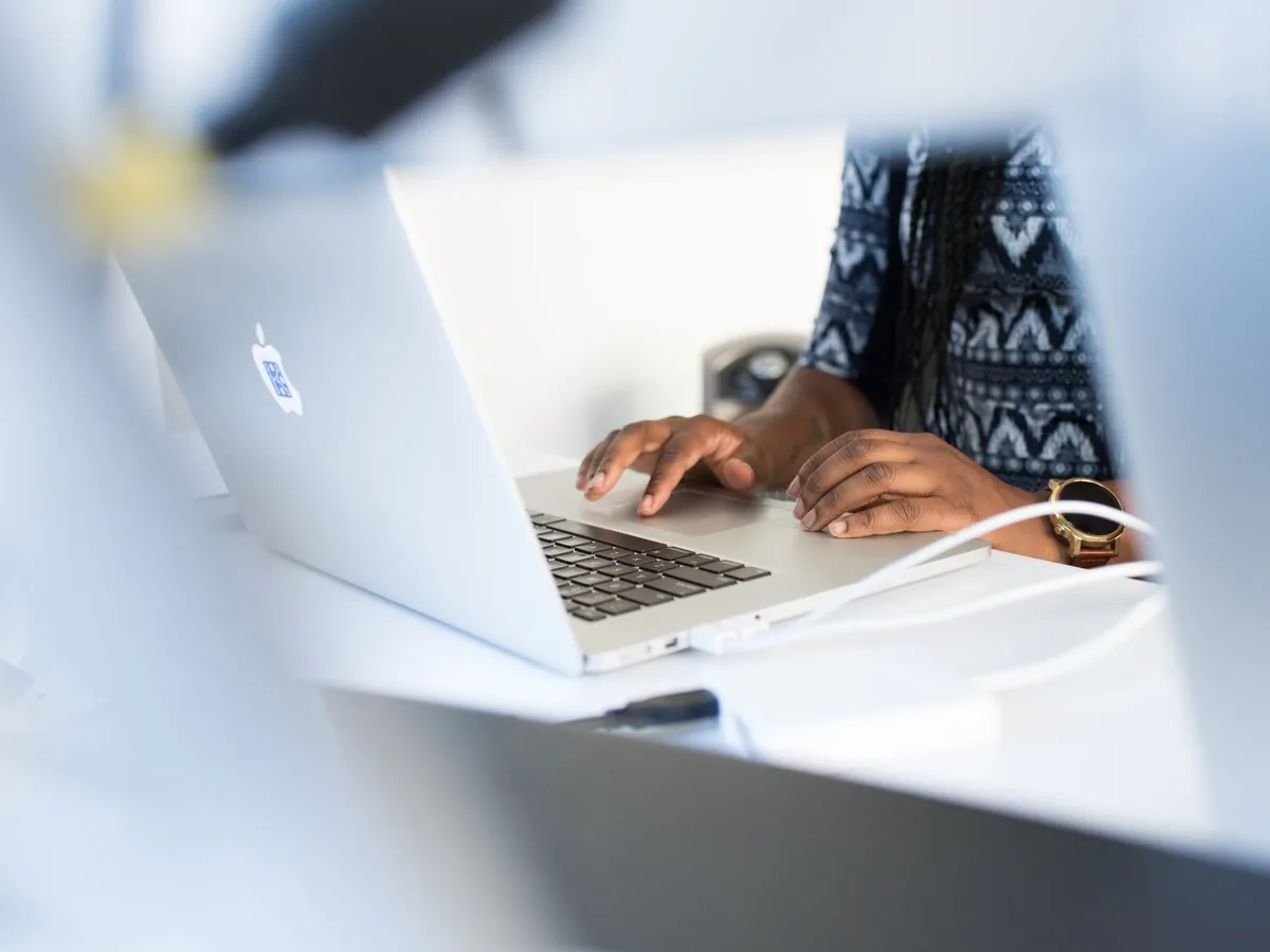 Femme tapant sur son ordinateur portable à son bureau, concentrée sur son travail