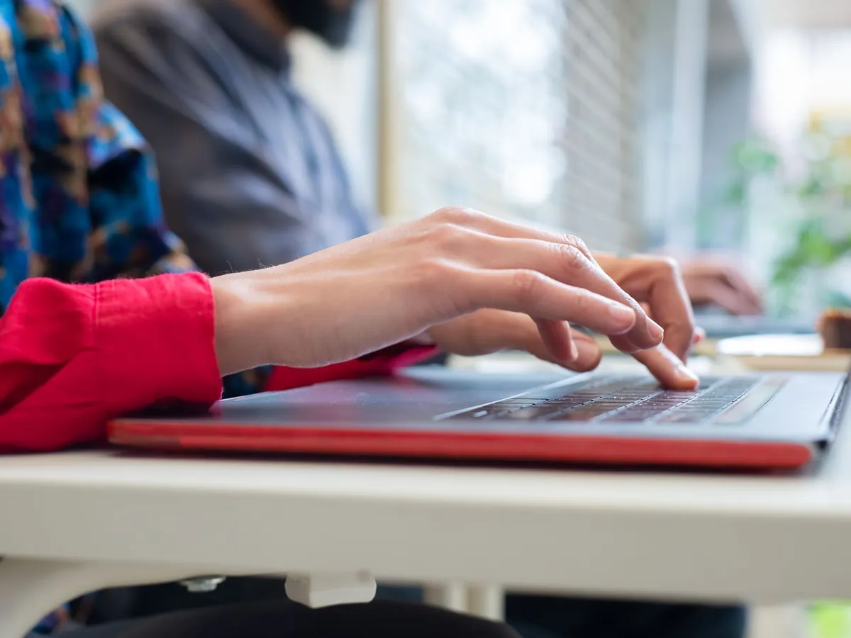 Personne tapant sur un ordinateur portable en intérieur au Portugal, productivité et technologie