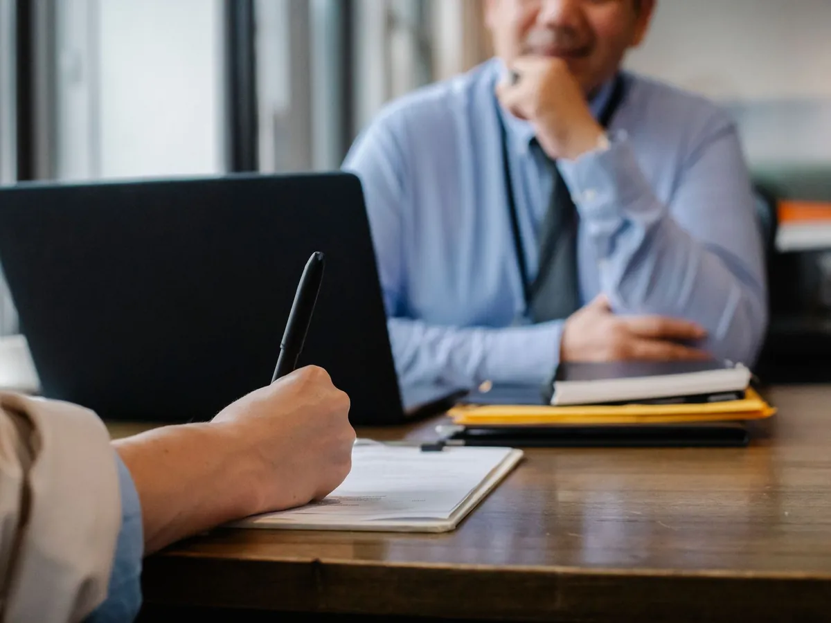 Gros plan sur une candidate anonyme remplissant un questionnaire d'embauche dans un bureau