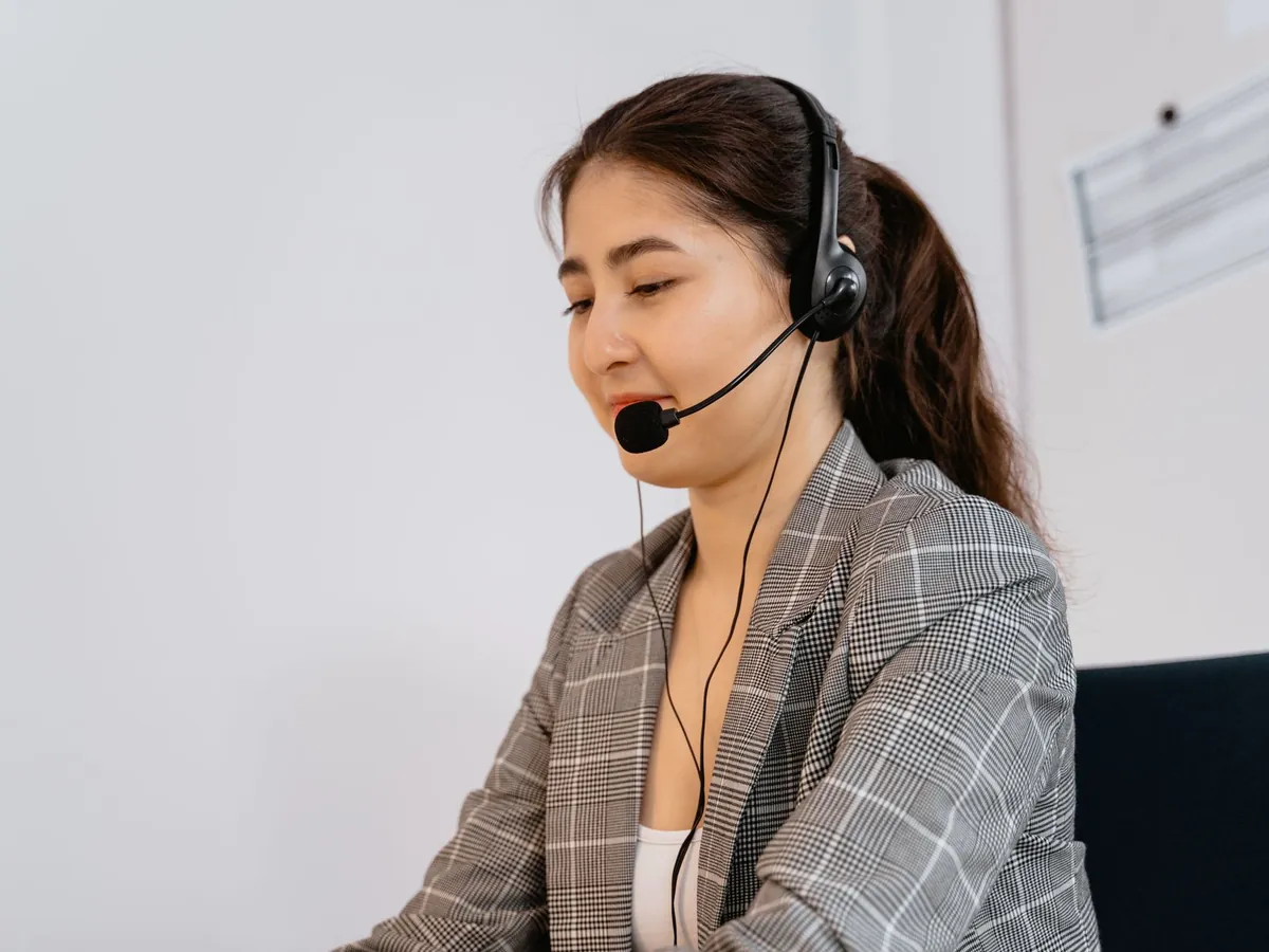 Professionnelle équipée d'un casque téléphonique, assurant le support client au bureau