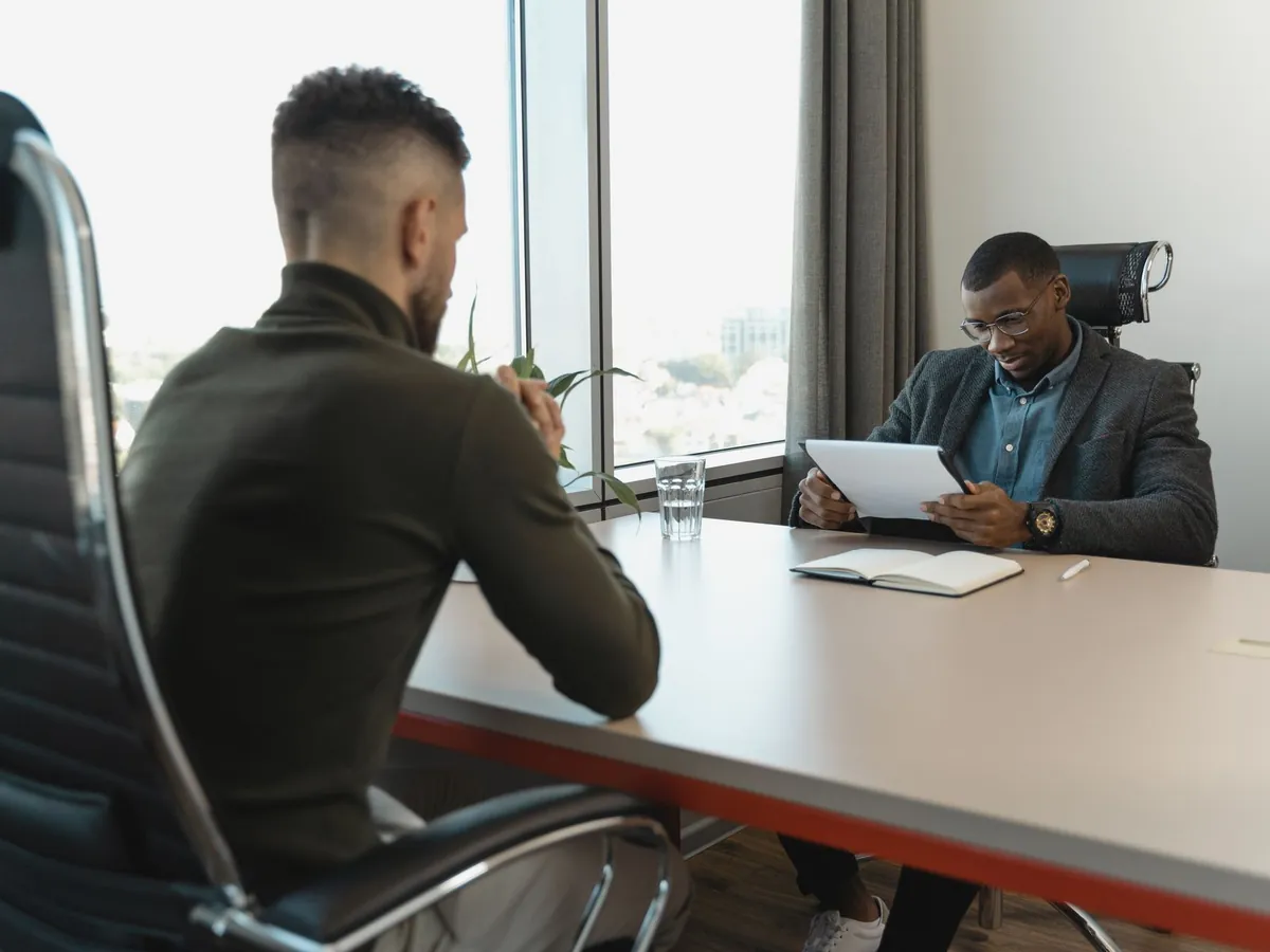 Entretien d'embauche se déroulant dans un bureau moderne entre deux hommes professionnels