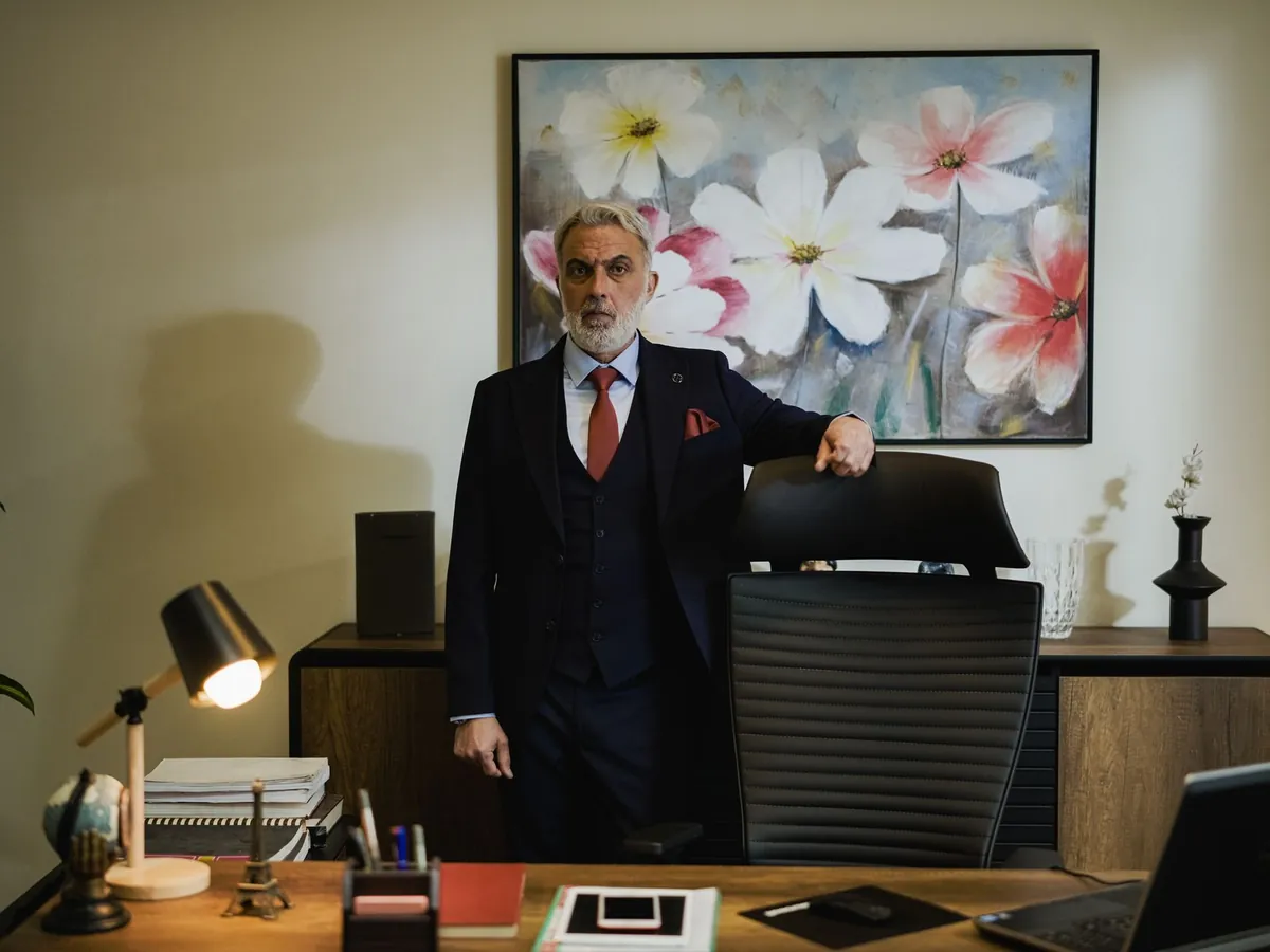 Chef d'entreprise debout à son bureau dans son bureau de direction