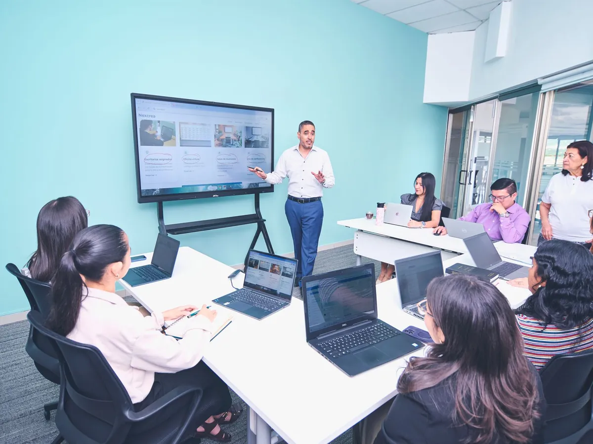 Équipe présentant un projet dans un bureau moderne à l'aide de technologies numériques