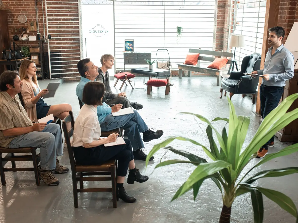 Groupe d'adultes aux profils variés en atelier, dans un loft au style branché