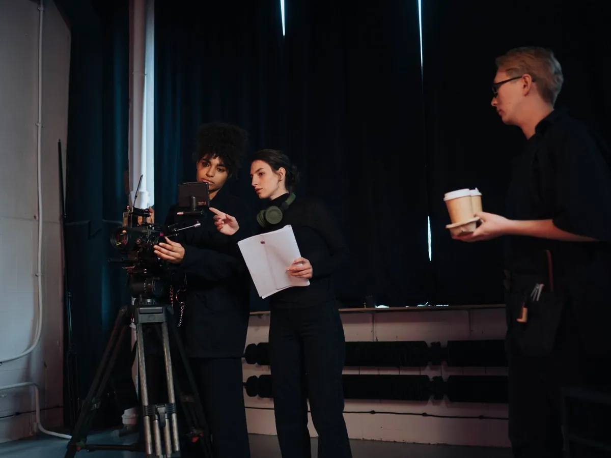 Équipe de tournage préparant une prise avec caméra et script dans un studio