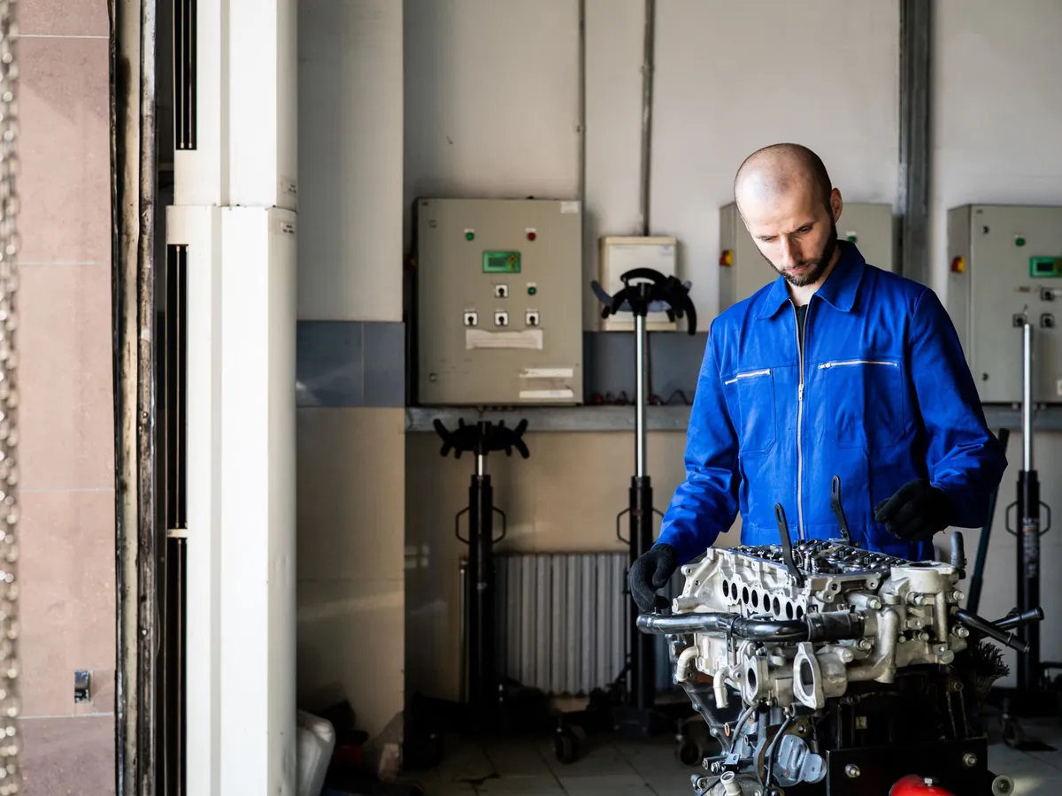 Technicien en bleu de travail au poste de travail dans un atelier industriel