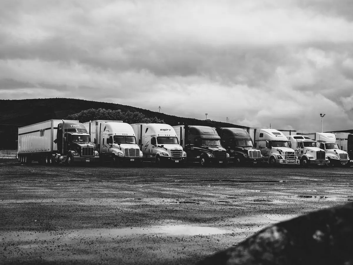 Camions de transport alignés sur un parking en noir et blanc