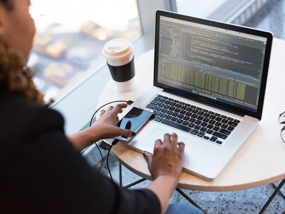 Professionnelle construisant une application sur son ordinateur portable dans un café