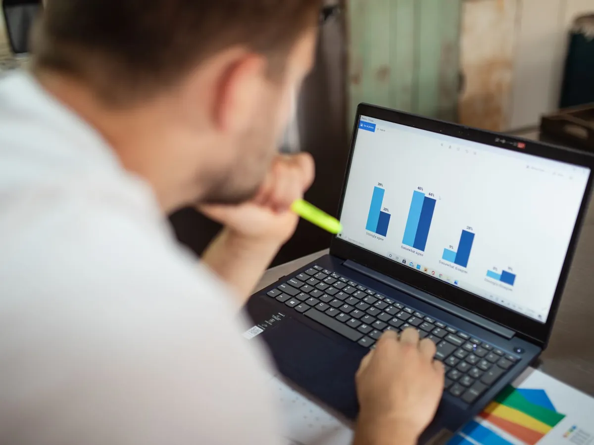 Analyste examinant des graphiques de données sur son ordinateur portable