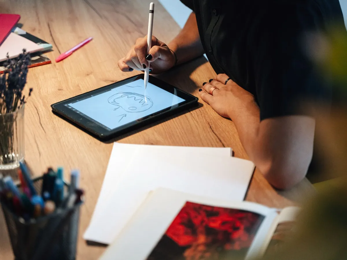 Graphiste dessinant sur une tablette graphique à son bureau