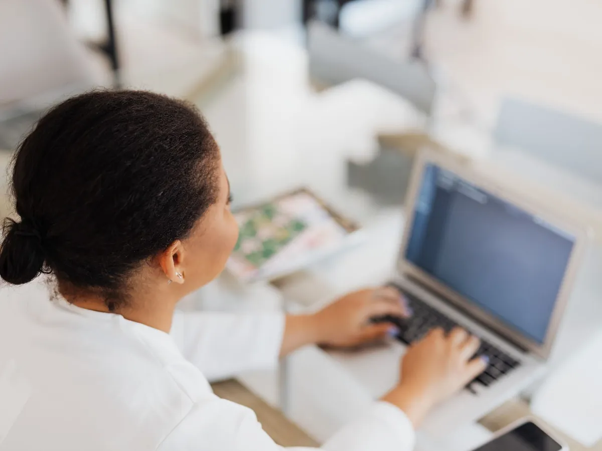 Professionnelle utilisant un assistant conversationnel sur son ordinateur portable