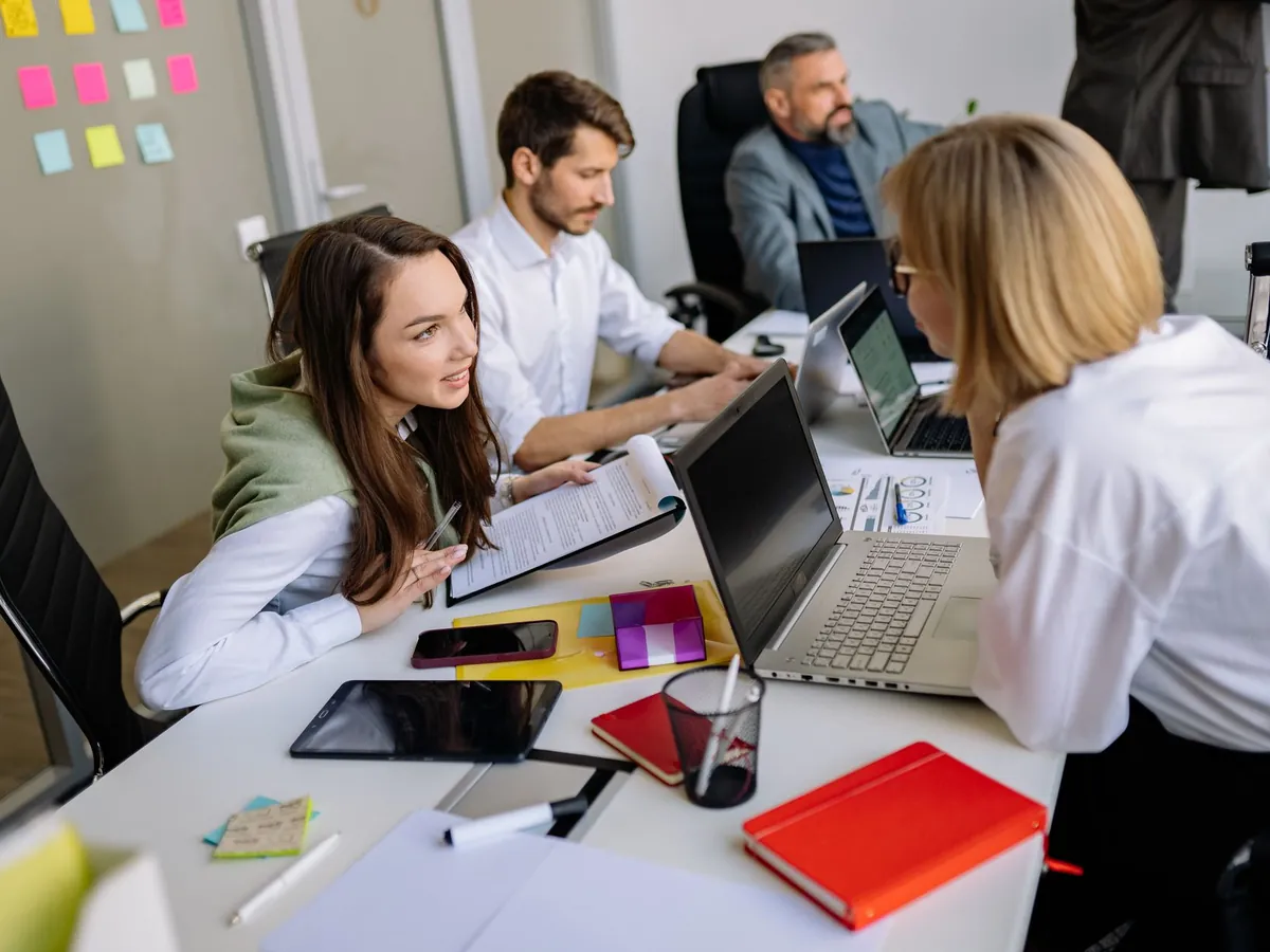 Équipe marketing réunie autour d'un ordinateur portable pour un travail créatif
