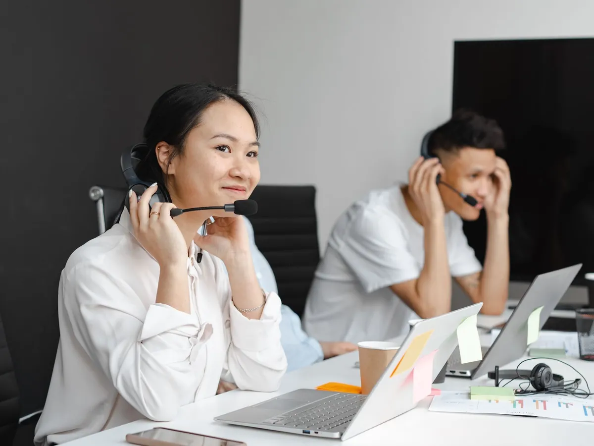 Deux conseillers du service client avec casques téléphoniques au bureau