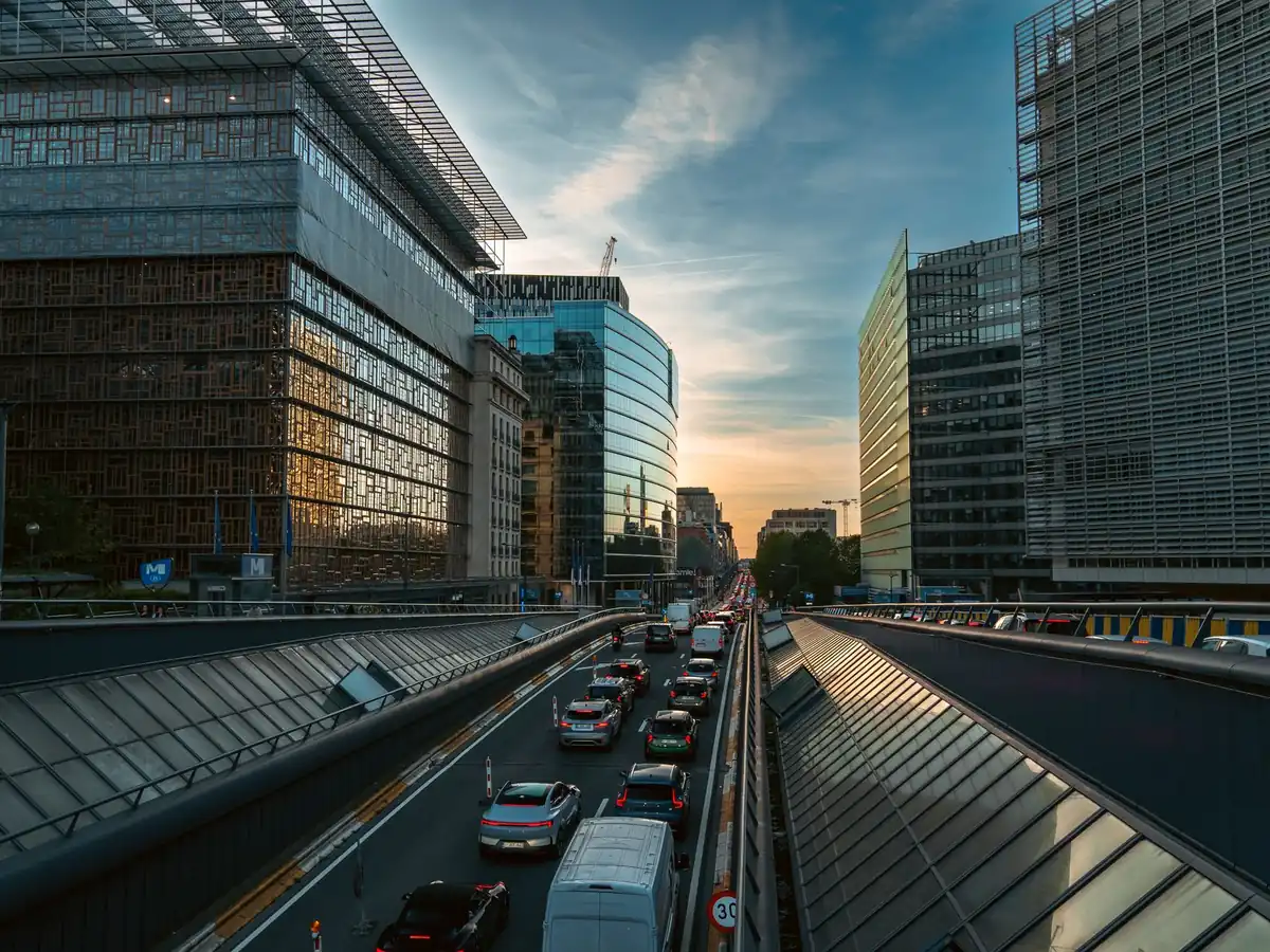 Rue animée de Bruxelles bordée d'immeubles de bureaux modernes au coucher du soleil