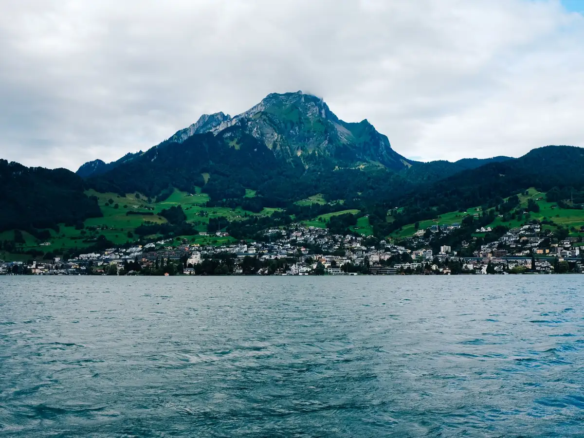 Ville lacustre pittoresque avec un majestueux arrière-plan de montagnes sous un ciel nuageux