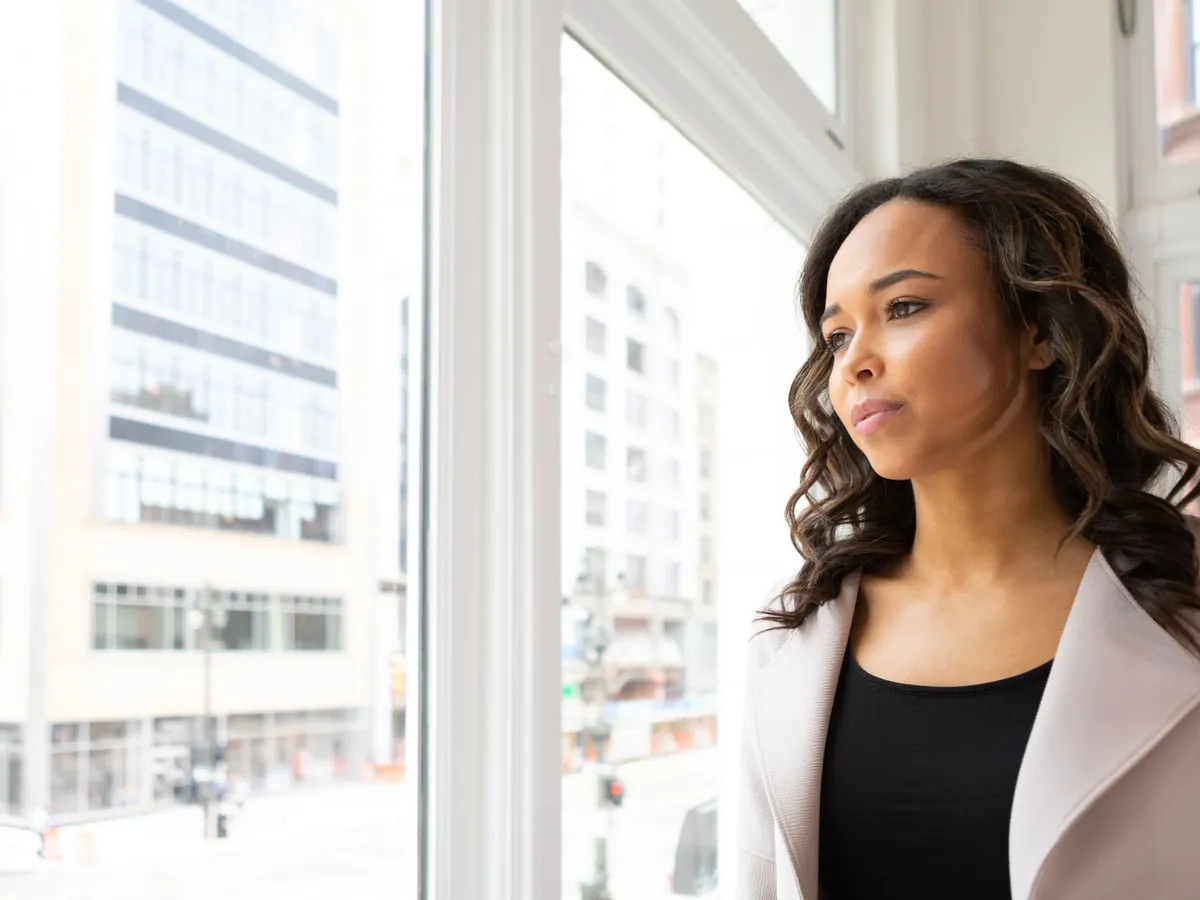 Femme pensive au regard tourné vers la fenêtre, à Detroit
