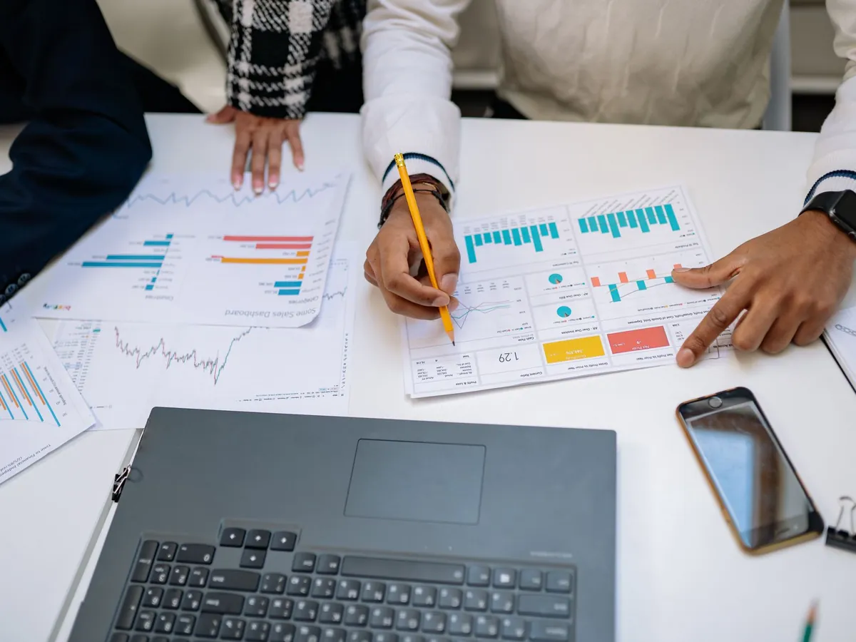 Équipe de professionnels travaillant sur des rapports financiers, graphiques et appareils à l'appui